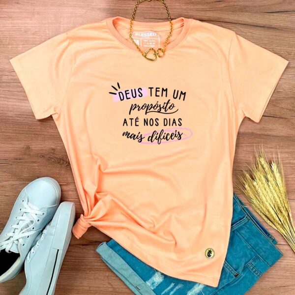Camiseta Feminina Branca Deus Tem Um Propósito Até Nos Dias Mais Difíceis